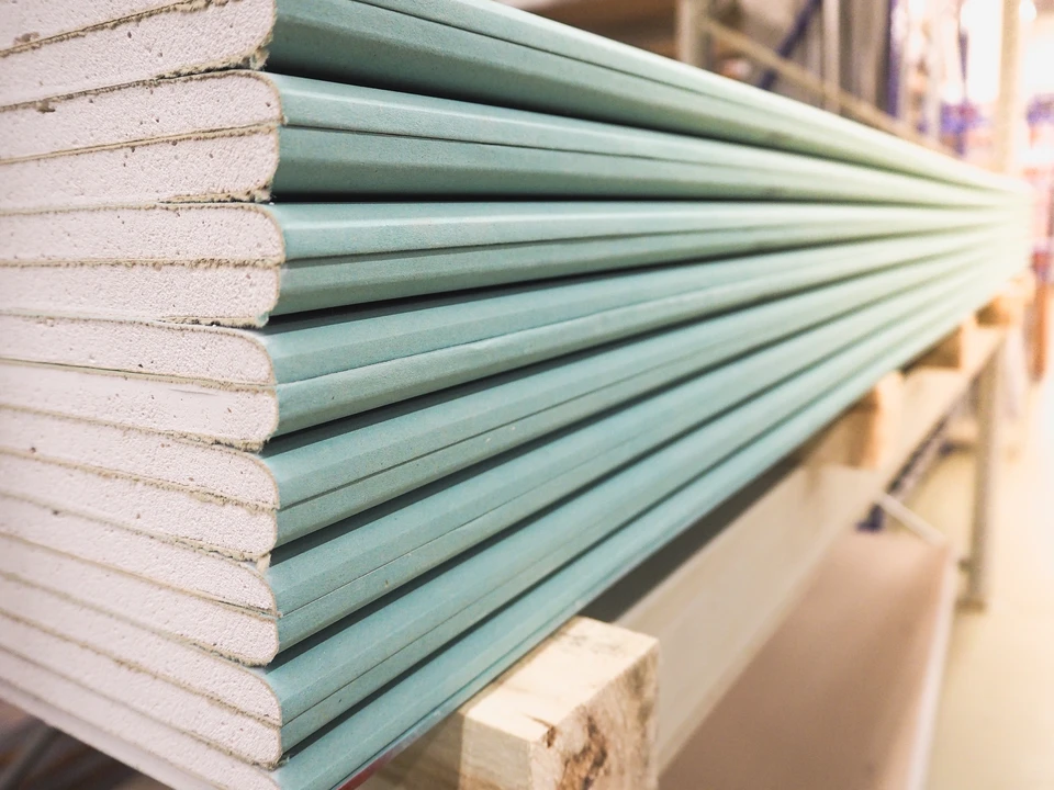 Int&eacute;rieur d'entrep&ocirc;t de mat&eacute;riaux de construction avec plaques de pl&acirc;tre empil&eacute;es sur palette en bois