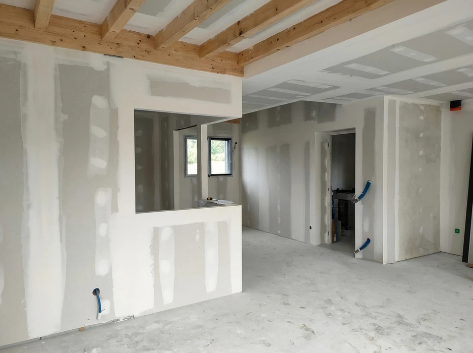 Chantier intérieur en cours de finition : plafond à caisson en plaques de plâtre BA13 bleu (Knauf ou Placo Phonique), avec joints enduits partiellement, moulures d'encadrement en staff blanc