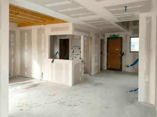 Chantier intérieur en cours, pièce à double hauteur sous plafond