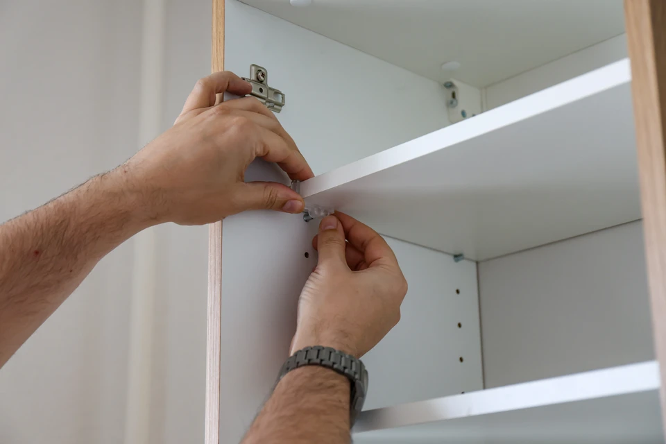 Atelier menuiserie intérieur avec deux artisans travaillant ensemble sur une pièce de bois